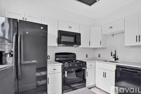 A kitchen with white cabinets and appliances.