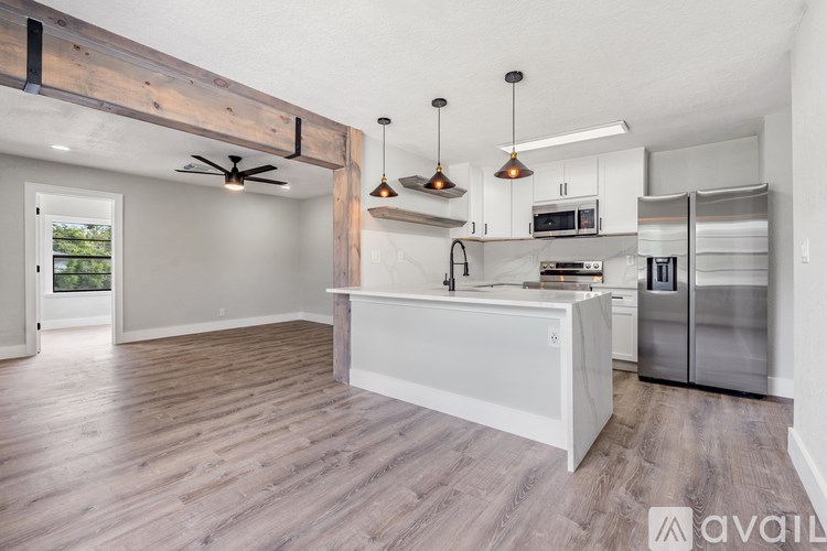 A kitchen with a wooden beam ceiling and a white island.
