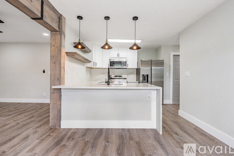 A kitchen with a white island and wooden floors.