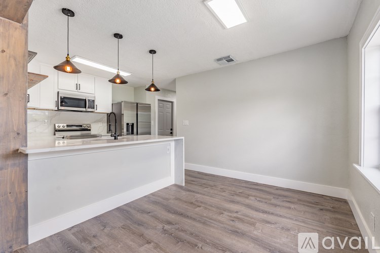 A kitchen with a white countertop and a microwave above it.