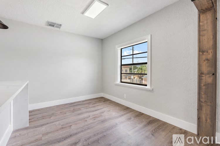 A room with a window showing a view of a building outside.