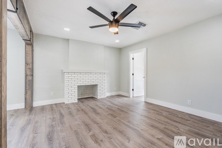 A room with a fireplace and a ceiling fan.