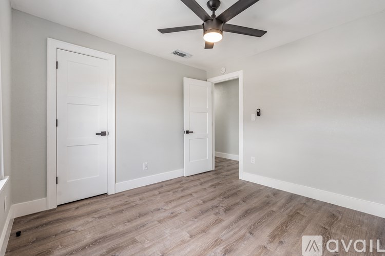A room with a ceiling fan and two doors.