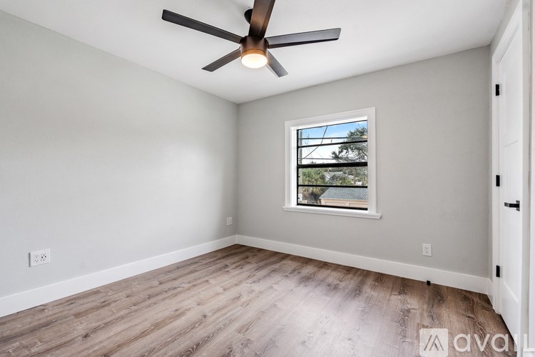 A room with a ceiling fan and a window.