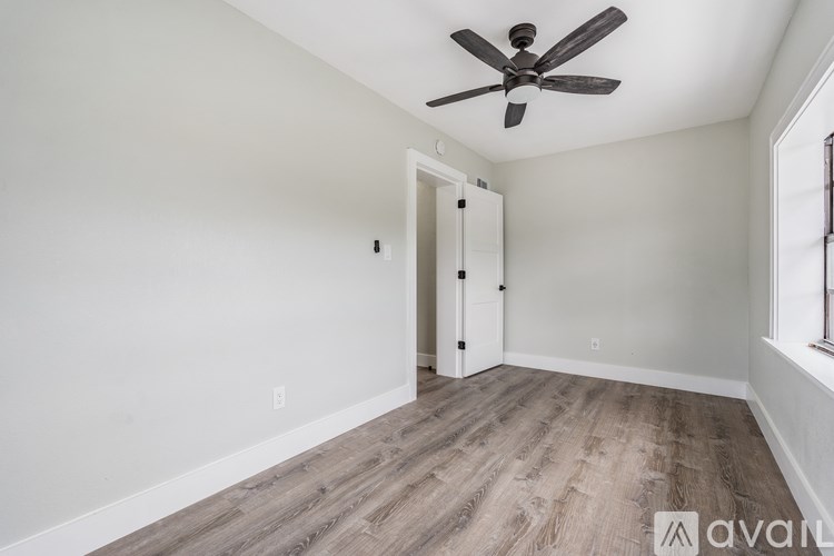 A room with a ceiling fan and a door.