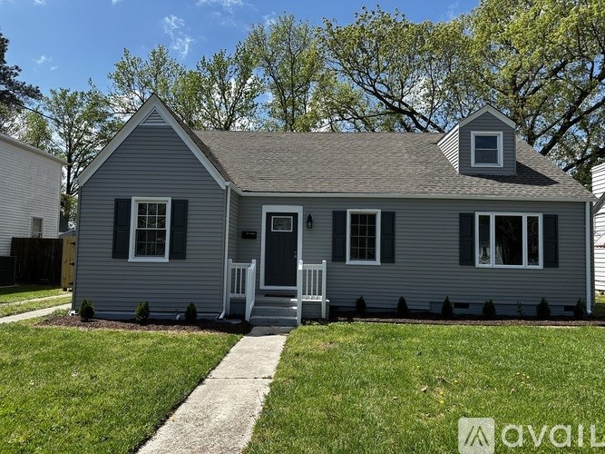 A small gray house with a white door and windows.