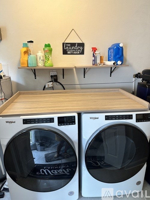 Two Whirlpool washing machines in a laundry room.