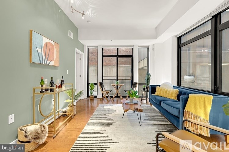 A living room with a blue couch and a yellow throw blanket.