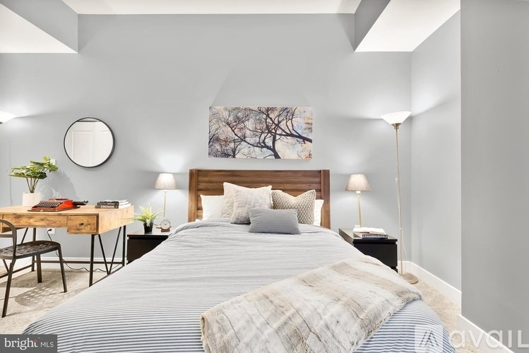 A bedroom with a bed, a desk, and a chair.