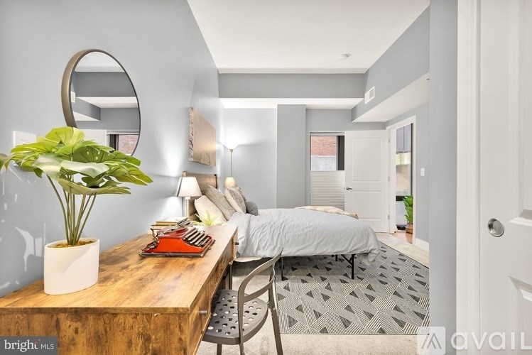 A bedroom with a bed, desk, and chair.