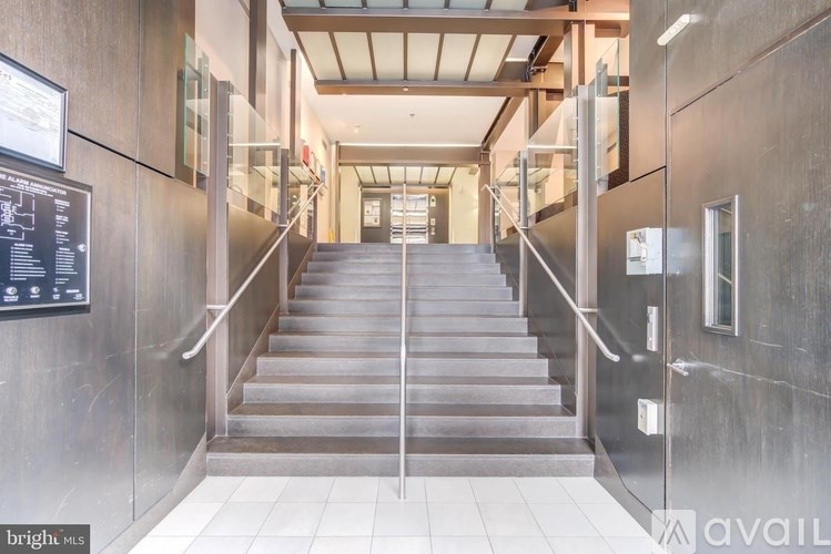 A long flight of stairs with a wall on the side and a sign on the wall.