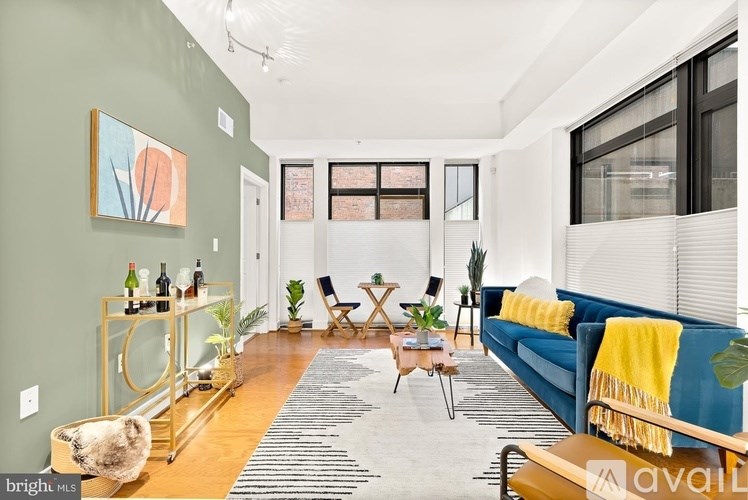 A living room with a blue couch and a yellow throw blanket.