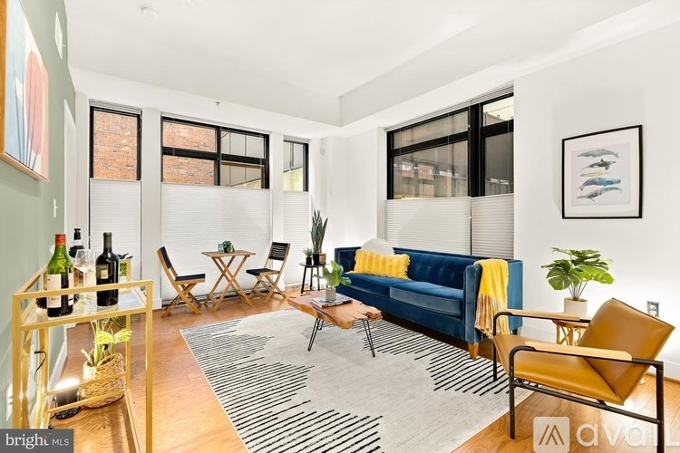 A living room with a blue couch, a wooden table, and a rug.