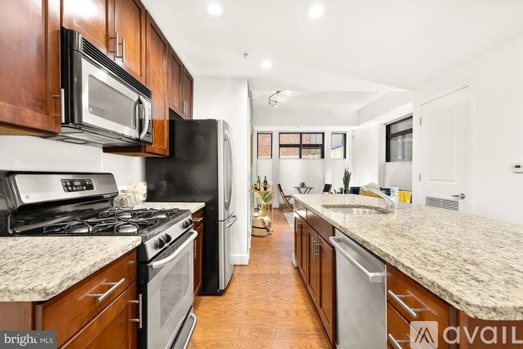 A kitchen with a black refrigerator, stove, and microwave.