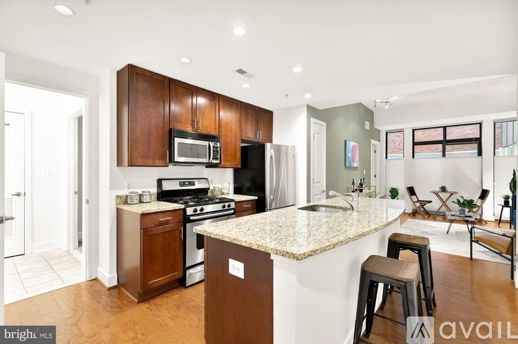 A kitchen with a granite countertop and wooden cabinets.