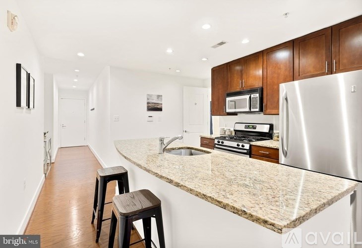 A kitchen with a granite countertop and stainless steel appliances.