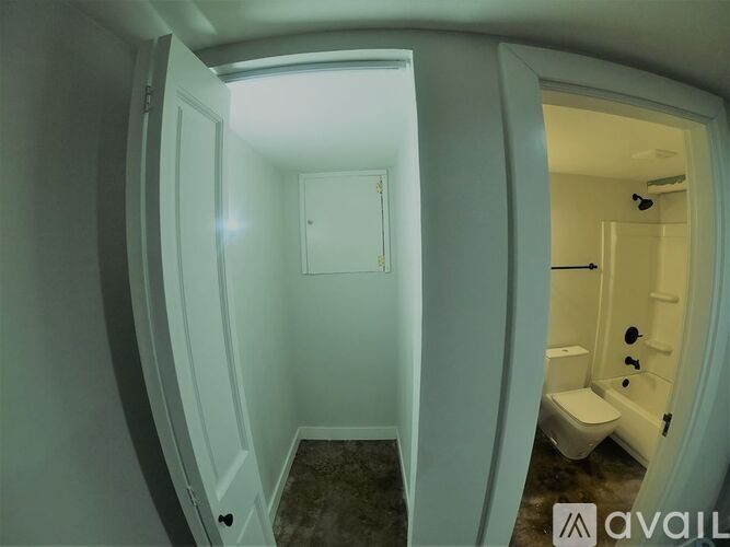 A bathroom with a toilet and sink is shown through a circular opening.