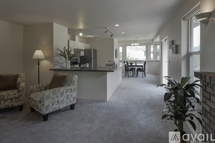 A living room with a couch, chairs, and a dining area.