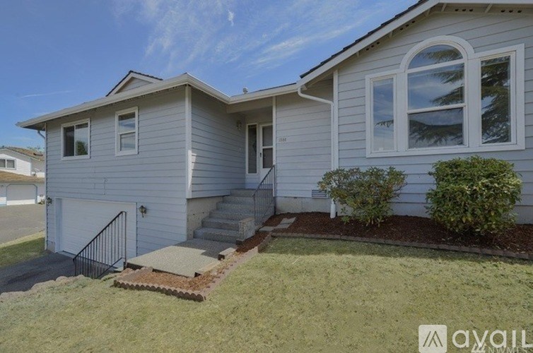 A house with a grey exterior and a white door is shown.