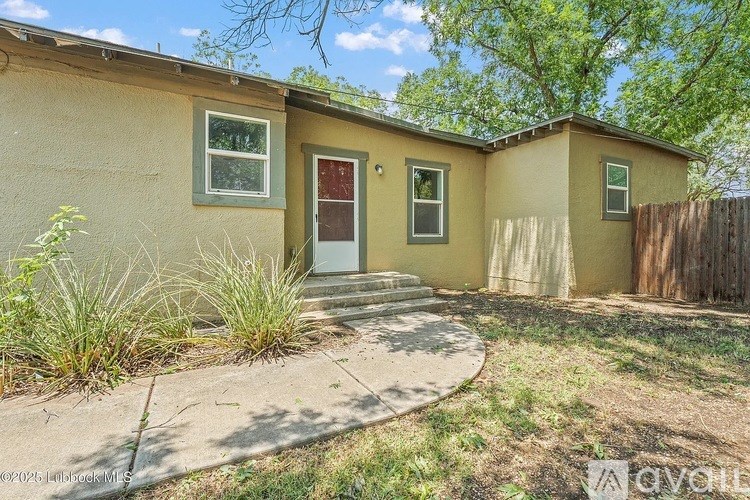 A small house with a red door and a brown fence.