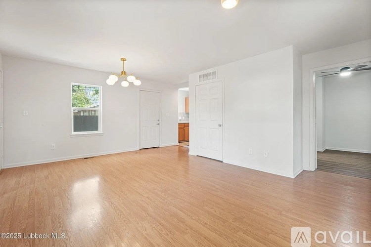 A large empty room with wooden floors and white walls.