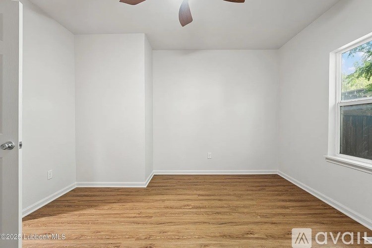 A room with wooden flooring and a ceiling fan.