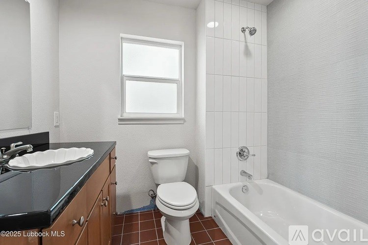 A white toilet sits next to a bathtub in a bathroom.