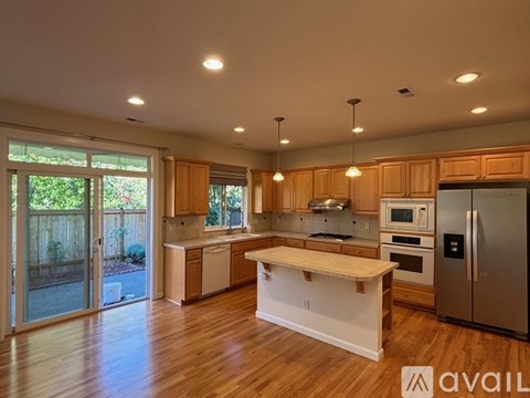 A kitchen with wooden cabinets and a refrigerator.
