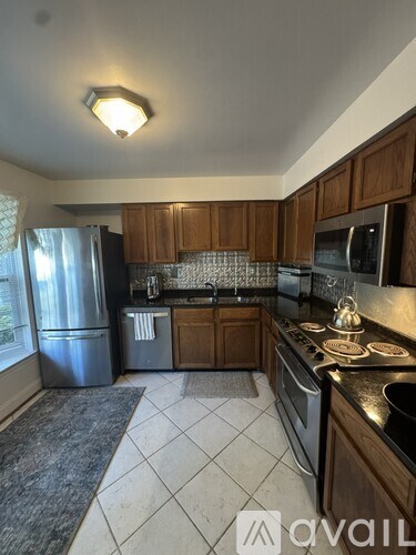 A kitchen with wooden cabinets and black countertops.