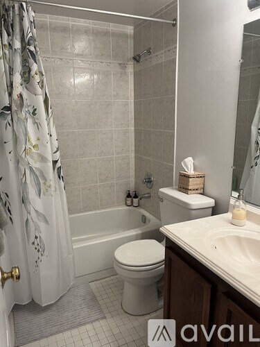 A bathroom with a toilet, sink, and shower.