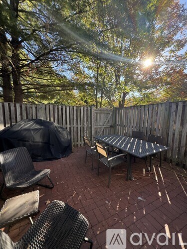 A patio with a table and chairs is covered with a black tarp.