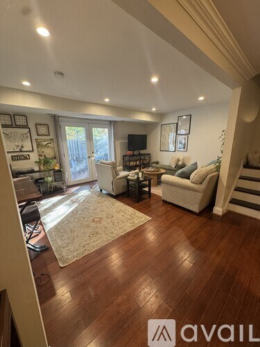 A living room with a couch, chairs, and a rug.