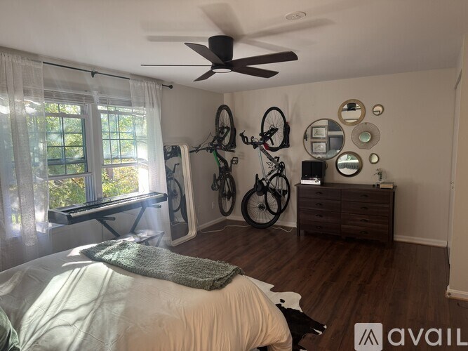 A bedroom with a bed, a dresser, and a bicycle hanging on the wall.