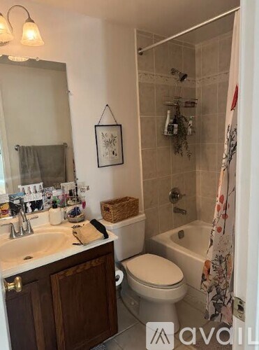 A bathroom with a toilet, sink, and shower.