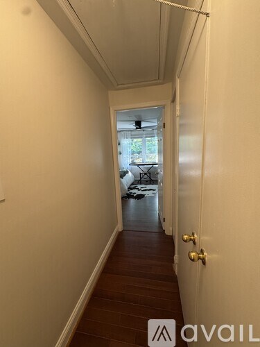 A hallway with a door on the right and a balcony in the distance.
