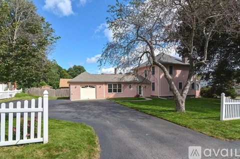 A house with a white picket fence in front.
