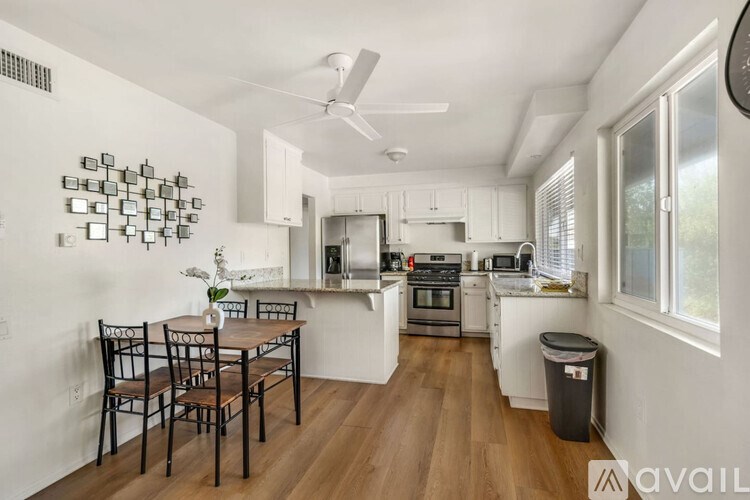 A kitchen with a dining table and chairs.