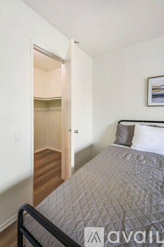 A bedroom with a bed and a picture on the wall.