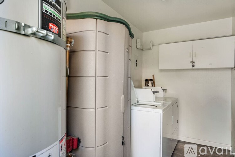 A small room with a washing machine and a fridge.
