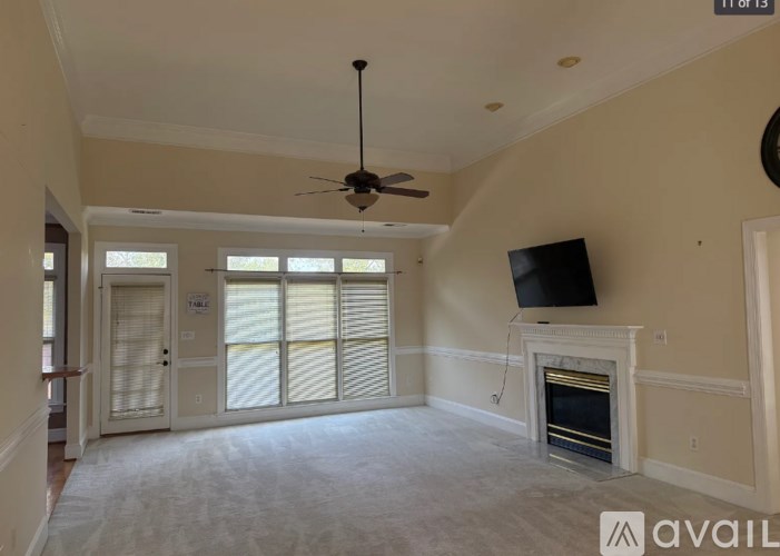 A living room with a fireplace and a flat screen TV mounted above it.