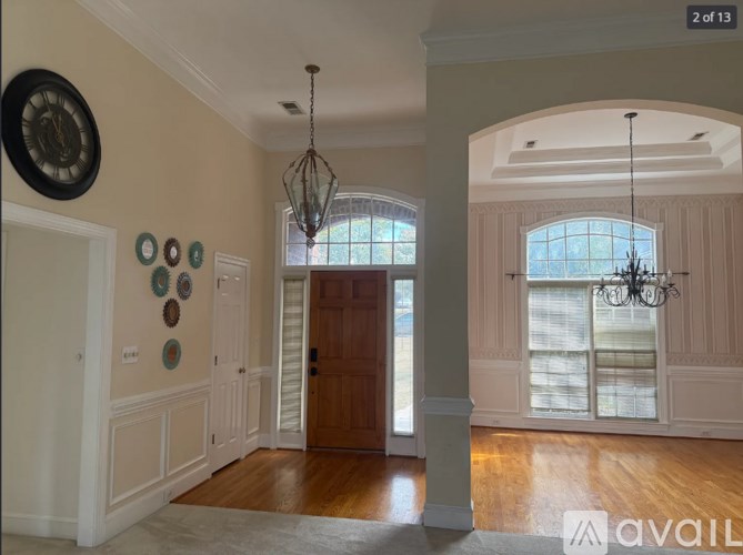 A room with a wooden floor and a chandelier hanging from the ceiling.
