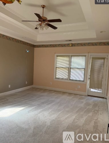 A room with a ceiling fan and a window with blinds.