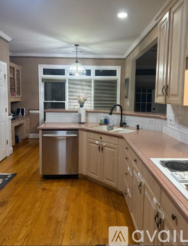 A kitchen with wooden floors and a stainless steel dishwasher.