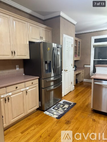 A kitchen with wooden cabinets and a black fridge.