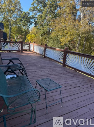 A wooden deck with a green metal chair and table.