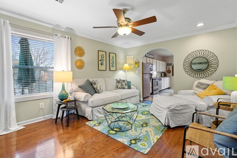 A living room with a white couch and a ceiling fan.