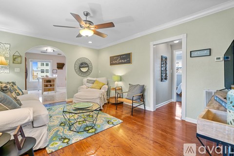 A living room with a white couch and a glass coffee table.