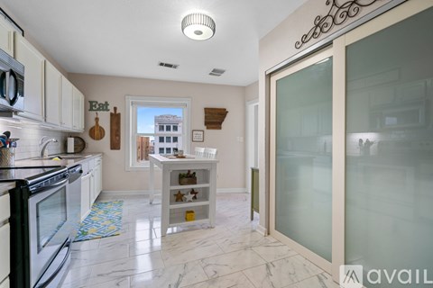 A kitchen with a black stove top oven and white cabinets.