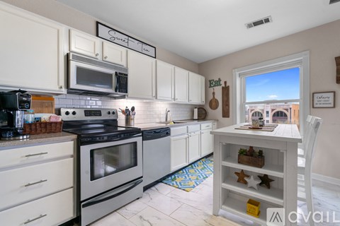 A kitchen with white cabinets and a black stove top oven.