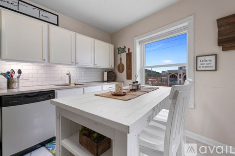 A kitchen with white cabinets and a white island.